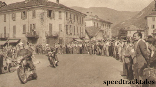 Photo - Shirt-sleeved crods at Gravellona watch the ISDT competitors come though. L Archer (BSA) is ahead of E. Dow (BSA) ISDT 1951 (speedtracktales archive)