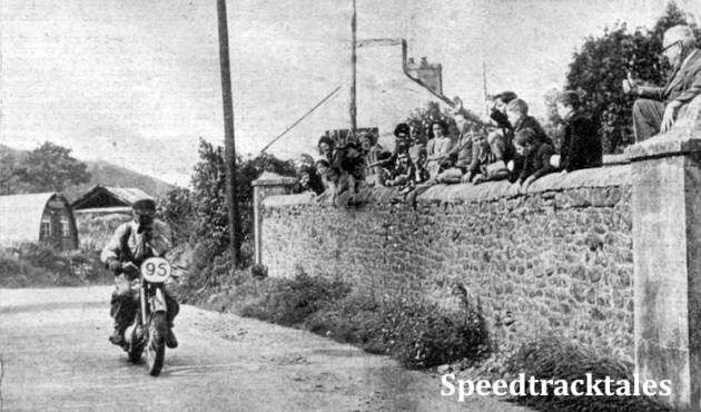 Photo - A Welsh welcome for a Czech. INterest in the INternational is shared by young and old among the inhabitants of Abergorlech, who raise a cheer for #95 A Vitvar (250 Jawa) of Czechoslovakia's Trophy team, as he rides through the street during Tuesday's run ISDT 1949 (Speedtracktales Collection)
