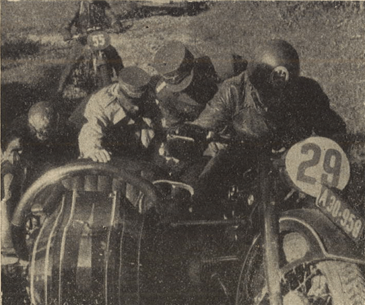 Photo – Sometimes it became very tough, and this picture shows, how Korpsführer Hühnlein [Head of the NSKK] himself gives a hand to help a stuck sidecar outfit. The rider is DDAC [Der Deutsche Automobil Club – the German Automobile Club] man #29 Schrimpf on the BMW R 17 outfit. ISDT 1939 (das Motorrad)