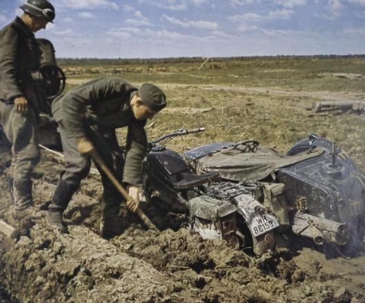 Photo - German despatch riders dig out their Zundapp motorbike which is bogged down in mud on the Eastern Front probably during the Spring thaw. (Image courtesy Imperial War Museum)