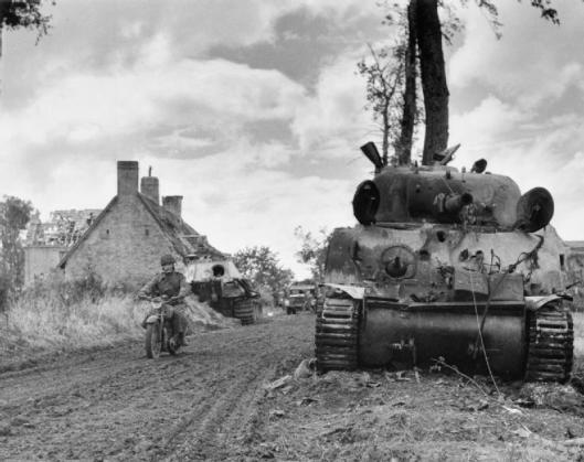 Photo - A motorcycle despatch rider passes a knocked-out Sherman tank and behind, a German Panther at Fontenay-le-Pesnel, 27 June 1944. (Image courtesy Imperial War Museum)