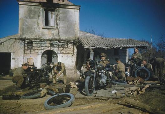 Photo - Motorcycles being assembled at a forward REME workshop by the 56 Infantry Troop Recovery Unit, Royal Electrical and Mechanical Engineers. (Image courtesy Imperial War Museum)