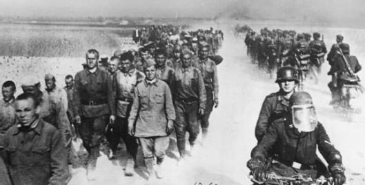 Photo - German motorcycle troops and infantry pass a long column of Russian prisoners during the advance into the Soviet Union, 1941. (Image courtesy Imperial War Museum)
