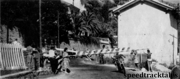 Photo - A competitor ducks under a barrier at a level crossing on the main Genoa line. Competitors were helped in this way whilst normal traffic was held up. ISDT 1949 (Speedtracktales archive)