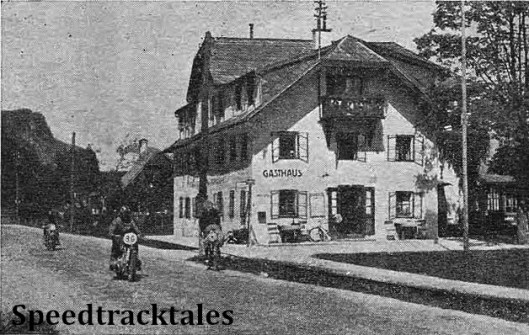 photo - The Italian E Catolini (Guzzi) following F. Mayer (BMW) in Wolfgang on the second day. The picturesque hotel, with overhanging eaves, is typical of the district. ISDT 1939 (Speedtracktales Collection)