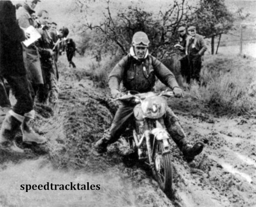 Photo - Before a big crowd, #207 Peter Fletcher (346 Royal enfield) of Briain's Vase 'A' team, footslogs through deep mud on Friday afternoon. ISDT 1961