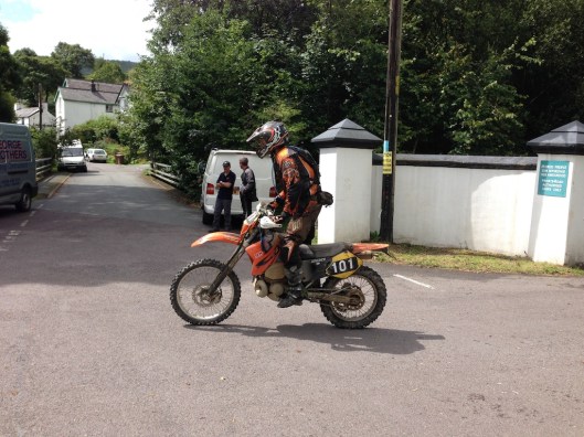 Photo - A rider competing in the Powys Enduro crosses the road from Llanwrin to Machlwyd at Aberangell, part of the route past ISDT's took to reach the Bwlch y Groes which is a couple of miles away
