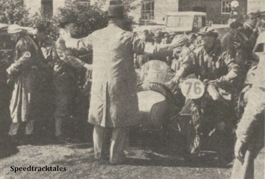 Photo - Not a community song leader, but the marshal at the lunch check trying to hold back the crowd of competitors storming the control. The rider in front is the German #76 L Kraus (BMW Sc) - ISDT 1938 (image courtesy Morton Media)