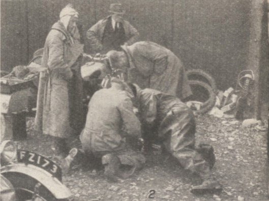 Photo - Trouble with the tyres - a group in a huddle over last minute preparations. At Llandrindod many such scenes were being enacted last week-end just before the competitors were due to present their machines for official scrutiny - ISDT 1938 (image courtesy Morton Media)