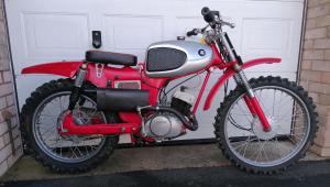 Photo of off-road motorbike standing by garage door